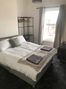 a bedroom with a bed with two towels on it at Lovely detached Cottage, Flint in Flint