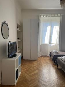 uma sala de estar branca com uma televisão e uma cama em HAVIP em Milão