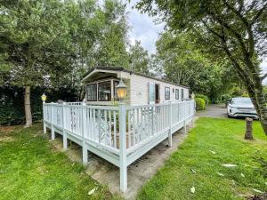 a white house with a porch on a yard at Superb Caravan With Decking At Southview Holiday Park Ref 33093s in Skegness