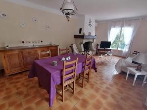 comedor con mesa púrpura y cocina en Aux portes de la Camargue en Jonquières-et-Saint-Vincent
