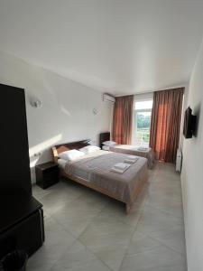 1 dormitorio con 2 camas y ventana grande en KARD HOUSE en Kobuleti