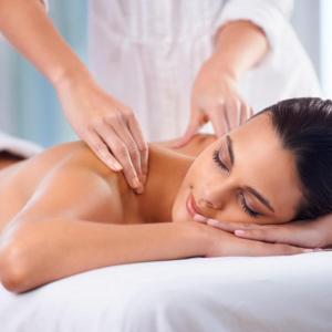 a woman getting a back massage in a spa at Cabañas Rústicas dentro de la Finca El Castillo in La Cabrera