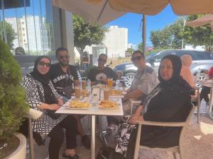 a group of people sitting at a table eating food at NOUARA Appart'hotel in Chefchaouen +1 photo