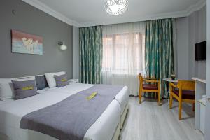 イスタンブールにあるUnique Suite Hotelの大きなベッドとテーブルが備わるホテルルームです。