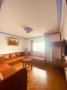 een woonkamer met een bank en een raam bij NOUARA Appart'hotel in Chefchaouene