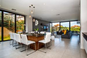 a dining room with a table and white chairs at Oceans Edge 5, Zimbali Estate in Ballito