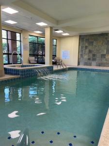 a large swimming pool in a building with water at Courtyard by Marriott Pittsburgh West Homestead Waterfront in West Homestead