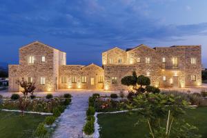 an exterior view of a large stone building with lights at Margazi Areopolis Luxury Rooms in Areopolis