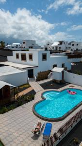 a person laying on a chair next to a swimming pool at Casa Abubilla in Tinajo