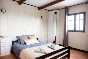 a bedroom with a bed with a table and a window at Casa Abubilla in Tinajo