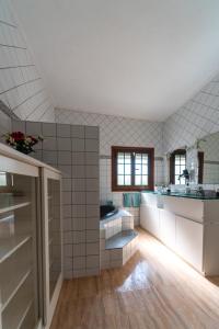 uma grande cozinha com paredes de azulejos brancos e pisos de madeira em Casa Abubilla em Tinajo