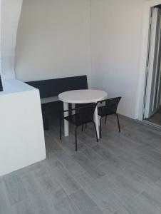 a white table and two chairs in a room at VAL apartmani, Stara Novalja in Stara Novalja