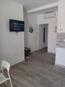 an empty room with a chair and a tv on the wall at VAL apartmani, Stara Novalja in Stara Novalja