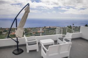 een balkon met stoelen, een tafel en een parasol bij Casa Merce in Arecida