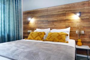 1 dormitorio con 1 cama grande y cabecero de madera en Okean Apartments, en Ierissos