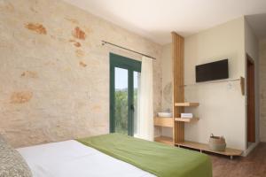a bedroom with a bed and a large window at Mouria Country House in Gállos