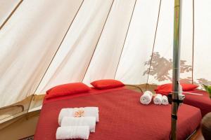 uma cama numa tenda com toalhas em Gole Alcantara mini Campeggio privato em Motta Camastra