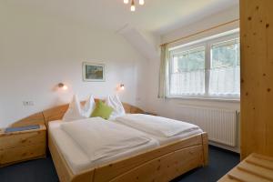 a bedroom with a bed with white sheets and a window at Chalet Helene in Mayrhofen