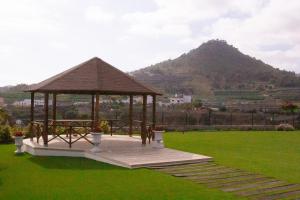 einen Pavillon auf einem Feld mit einem Berg im Hintergrund in der Unterkunft Finca Los Ángeles in Trapiche