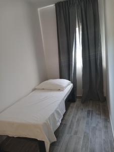 a small bedroom with a bed and a window at VAL apartmani, Stara Novalja in Stara Novalja