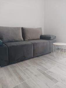 a black couch in a living room with a table at VAL apartmani, Stara Novalja in Stara Novalja