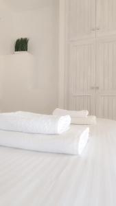 Hay dos toallas blancas encima de una cama. en Spilia, en Stavros