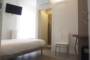 een slaapkamer met een bed, een stoel en een raam bij VILLA FENIX OSIO SOTTO in Osio Sotto