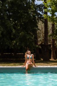 una mujer en bikini en una piscina en Villa Encantamiento - Dimora Gelsomino - Masseria Storica nel cuore della Puglia con piscina, en Latiano