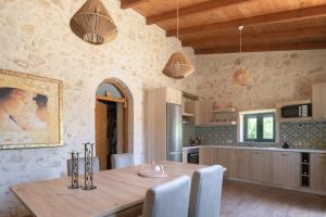 uma cozinha e sala de jantar com uma mesa de madeira em Mouria Country House em Gállos
