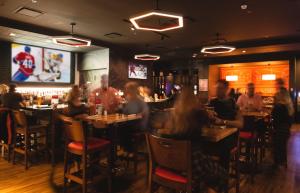 a group of people sitting at tables in a restaurant at Delta Hotels by Marriott Saguenay Conference Centre in Saguenay