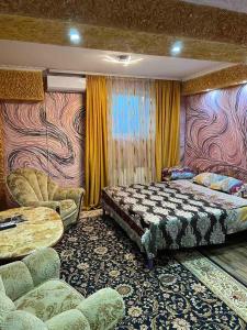 Schlafzimmer mit einem Bett, einem Tisch und Stühlen in der Unterkunft Golden Rose in Chişinău