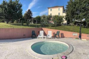 ein kleiner Pool mit Stühlen und einem Zaun in der Unterkunft La Dispensa in Montalto delle Marche