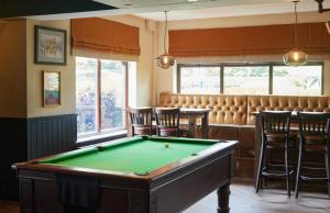 una sala de billar con una mesa de billar y un bar en The Broughton Hotel by Greene King Inns en Milton Keynes