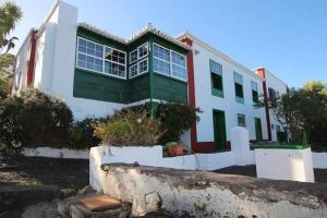 una casa bianca con una finestra verde e rossa di Casa Vicente Vista al mar y montaña a Breña Alta