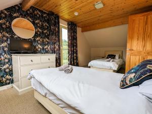 a bedroom with two beds and a large window at Elm Escapes in Knighton