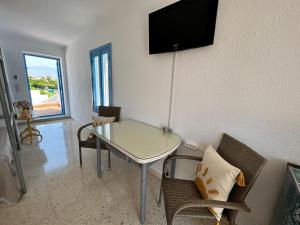 a living room with a table and a tv on the wall at Casa Manuela frente al Mar in Roquetas de Mar