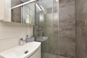 een badkamer met een wastafel en een glazen douche bij Apartment Valter 2284 in Medulin +35 foto's