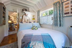 Schlafzimmer mit einem Bett mit einer blauen und weißen Bettdecke in der Unterkunft Alec Hill's Bakehouse in Wangford