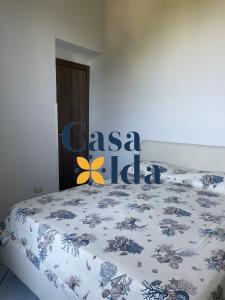 a bedroom with a bed with a blue and white comforter at Amalfi Coast Casa Ida in Vietri sul Mare