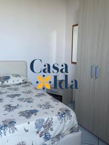 a bedroom with a bed with a casa hello sign on the wall at Amalfi Coast Casa Ida in Vietri sul Mare