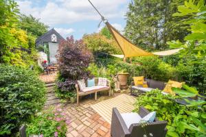 a patio with a hammock in a garden at Alec Hill's Bakehouse in Wangford