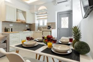 a kitchen with a table with plates and fruit on it at Philisios Home 1 in Naxos Chora