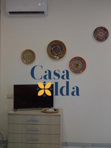 Amalfi Coast Casa Ida في فيتري: جدار مع علامة و casa india وأطباق عليه