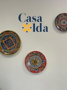 three plates on a wall with the casa india logo at Amalfi Coast Casa Ida in Vietri sul Mare