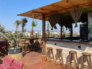 un bar con taburetes de madera, mesas y sillas en AURORA SIĞACIK HOTEL, en Seferihisar