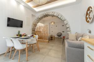 een keuken en een woonkamer met een tafel en stoelen bij Philisios Home 1 in Naxos Chora