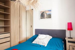 a bedroom with a blue bed and a closet at Le cabanon de Valérie in Sanary-sur-Mer