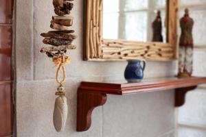 ein Spiegel und ein Regal mit einer Feder an einer Wand in der Unterkunft Le Cabanon de Valérie in Sanary-sur-Mer