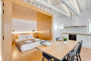 a bedroom with a bed and a table and chairs at Miragaia Apartments by DA'HOME in Porto