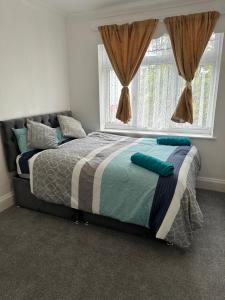 a bedroom with a large bed with a window at Gorgeous 5 bedroom house in Hither Green